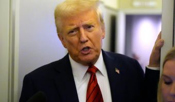 President Donald Trump speaks to reporters aboard Air Force One. His administration has issued a freeze on all government loans and grants (AP)